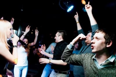 Танцующие гости вскидывают руки под живую музыку